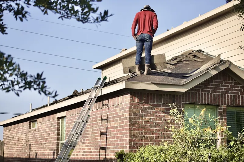 Professional roofer working on a residential roof in Sibley